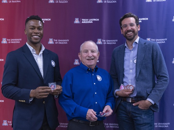 Ike Chinyere, Steven Goldman, and Jordan Lancaster with their patent coins.