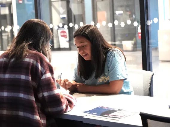 Two students sitting at a table in the Catalyst Center. 