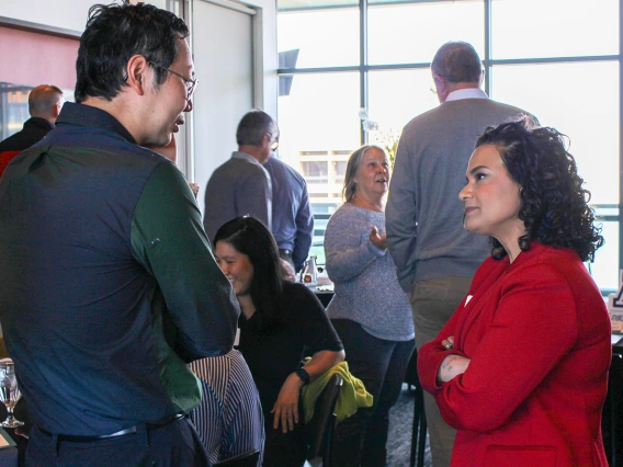 Two individuals talking at a luncheon. 