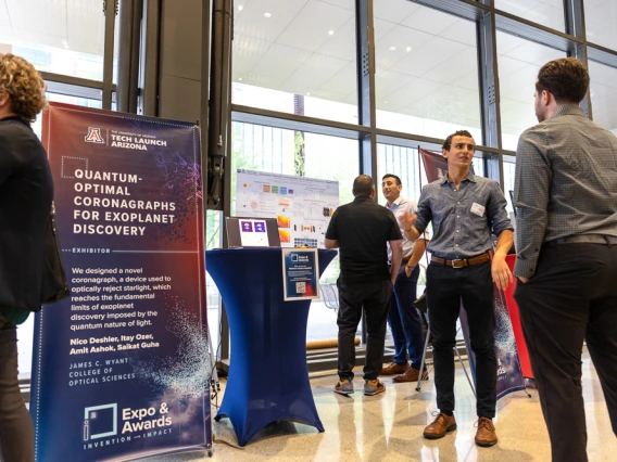 Nicolas Deshler speaks with a visitor at his team's expo table. 