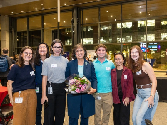 Inventor of the Year Robbie Brinton holds a bouquet of flowers and poses with those who came to celebrate her accomplishment.