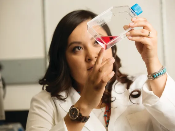 Student observing a fluid in a clear bottle at the College of Medicine Phoenix.