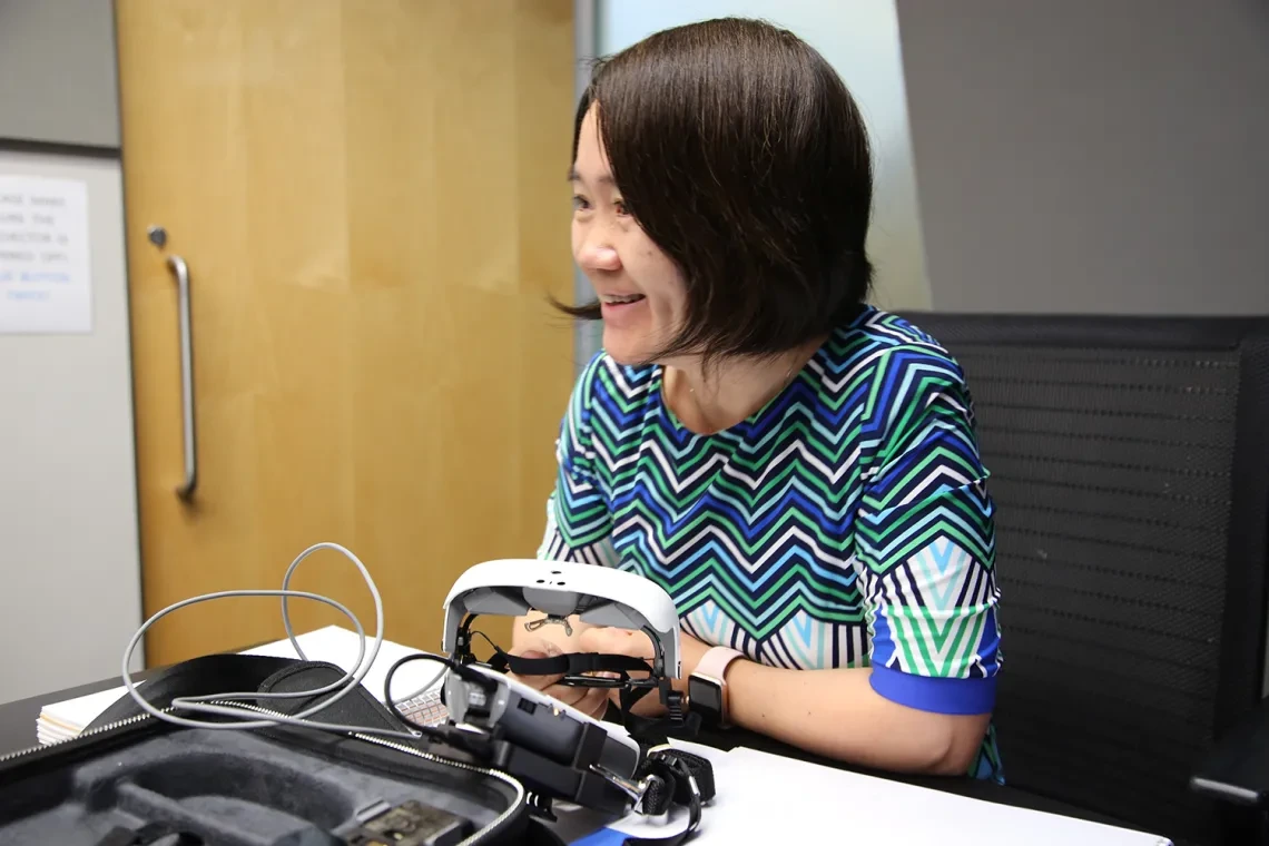 Inventor Hong hua smiling, working at the lab.