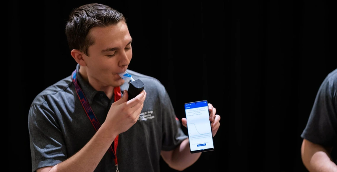 Capstone team member Nicholas Quatraro demonstrates the Inspiratory Muscle Strength Training (IMST) device at 2023 Craig M. Berge Design Day.