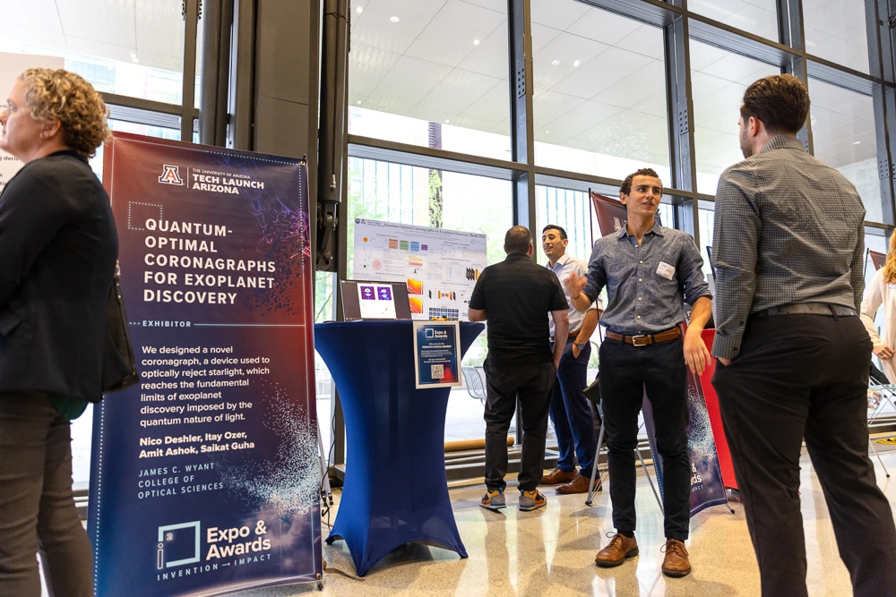 Nicolas Deshler speaks with a visitor at his team's expo table. 
