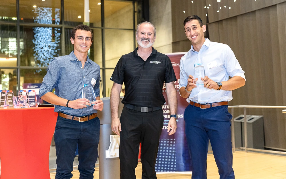 Doug Hockstad presents the Student Innovators of the Year honors to Nicolas Deshler (left) and Itay Ozer (right).