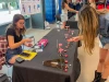 A student sits at a table selling the jewelry she made through the Student-Made program. 